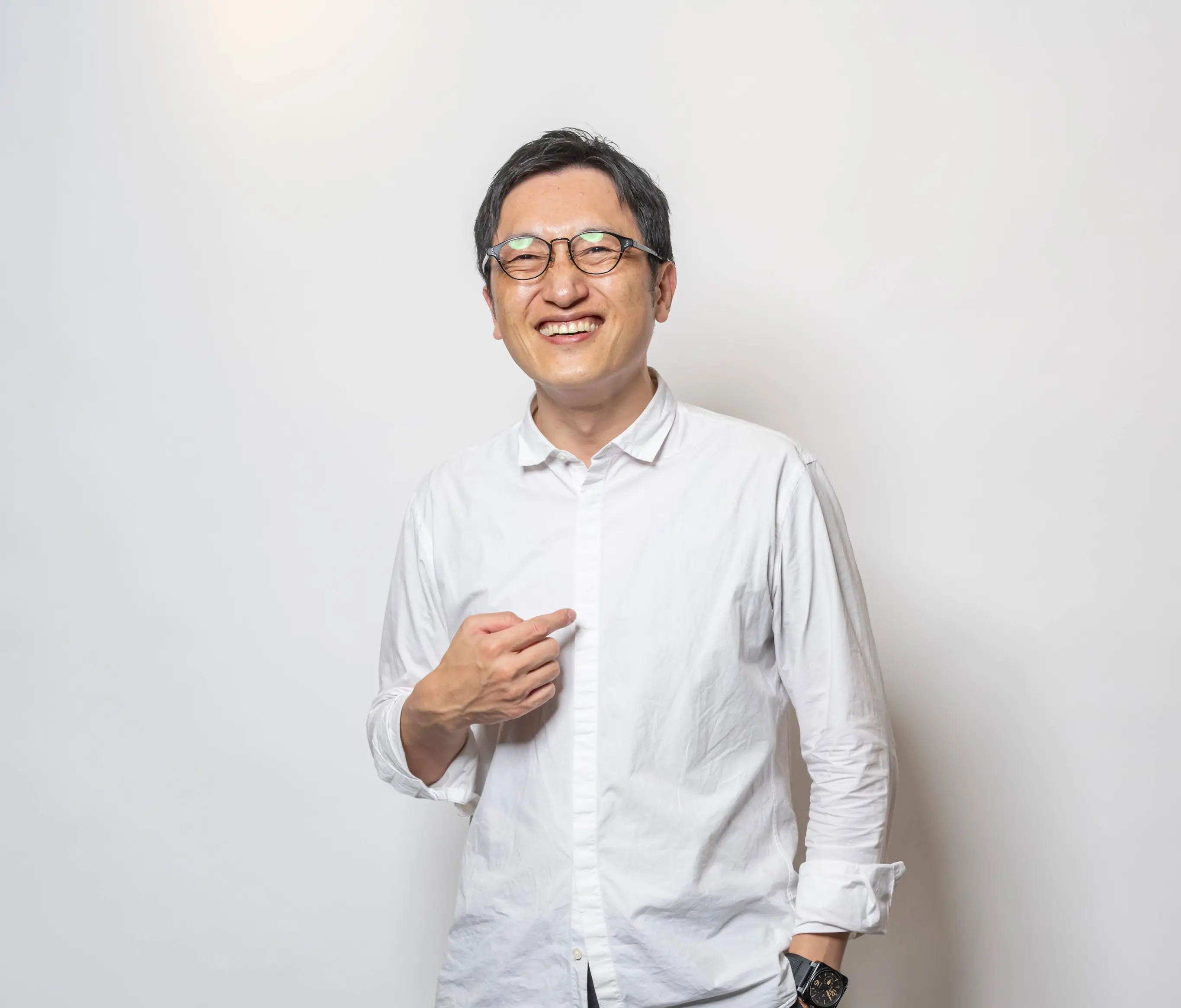 Smiling man in a white shirt against a light background.